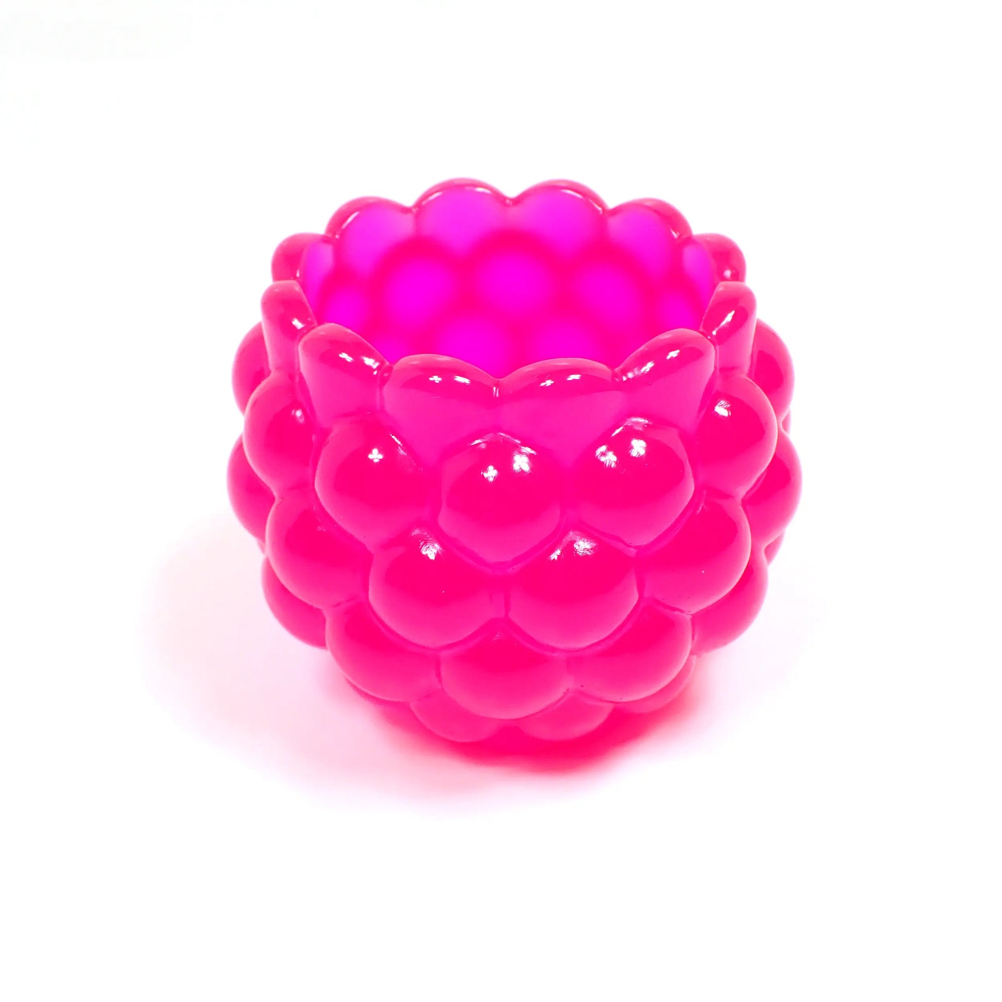 Side view of the neon pink resin bowl. It's bright pink in color with bumpy round pattern and scalloped top.