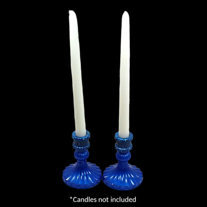 Photo on a black background showing the candle holders holding two white candles. The words "candles not included" is at the bottom of the photo.