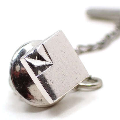 Angled front view of the Swank Mid Century vintage sterling silver tie tack. It is square shaped and has a smaller square with an angled indent design on one corner.