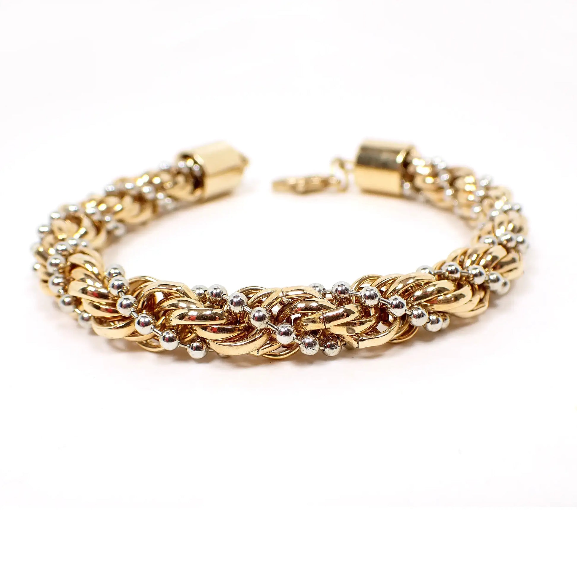 Enlarged view of the retro vintage twisted rope chain bracelet. The metal is mostly gold tone in color, including the lobster claw clasp at the end. It has a twisted rope design with a thin ball chain twisted in that's silver tone in color for a two tone look.