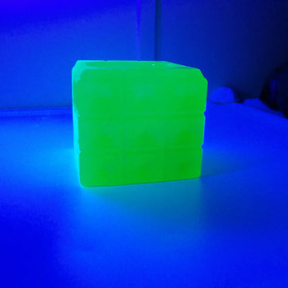 Photo showing how the handmade decorative trinket dish fluoresces under a UV light in a bright green color. 