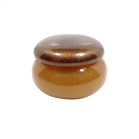 Side view of the small handmade resin round trinket box. The lid has a pearly brown resin color and the bottom is pearly golden honey yellow color.