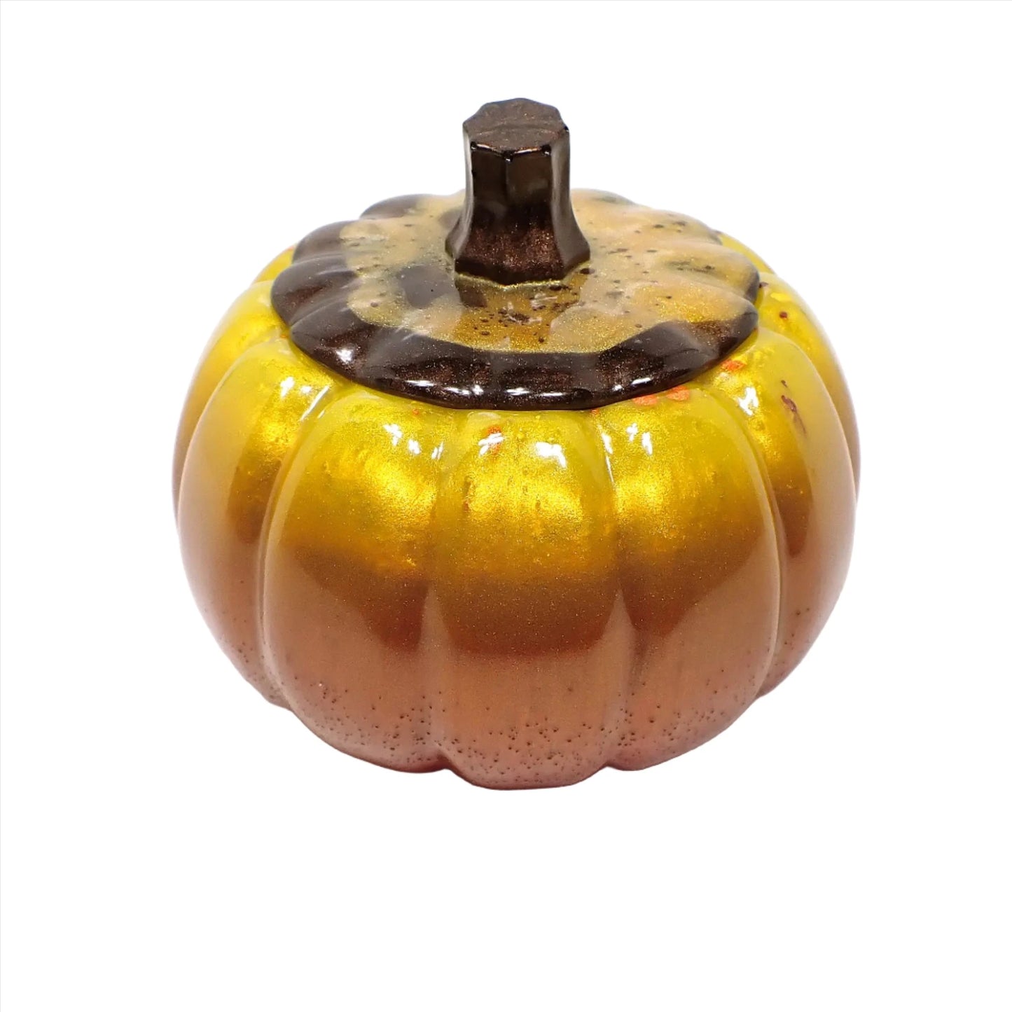 Side view of the handmade resin pumpkin trinket box. The lid has a pearly brown stem and a mix of pearly brown and gold color resin. The pumpkin part has shades of pearly yellow, then orange, then red at the bottom.