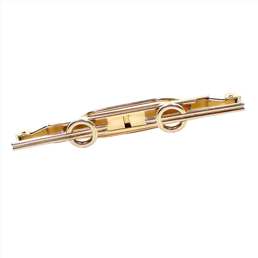 Front view of the Mid Century vintage Hadley Modernist tie bar. It is long and has a clip on each side. Each clip has double bars with open circles with the bars going through them at the end. 