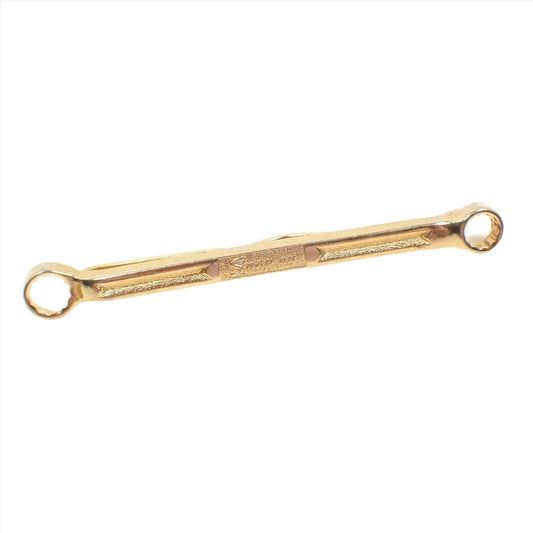 Front view of the Mid Century vintage Snap On tie bar. The metal is gold tone in color. It is shaped like a double ended box wrench with the Snap On logo in the middle. 
