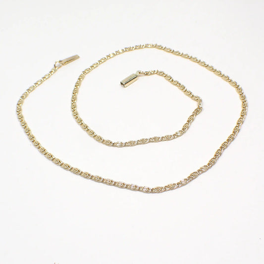 Top view of the Mid Century vintage chain necklace made in Germany. The metal is gold tone in color. The links are small S shaped snail link chain. There is a box clasp and tab at the ends of the chain.