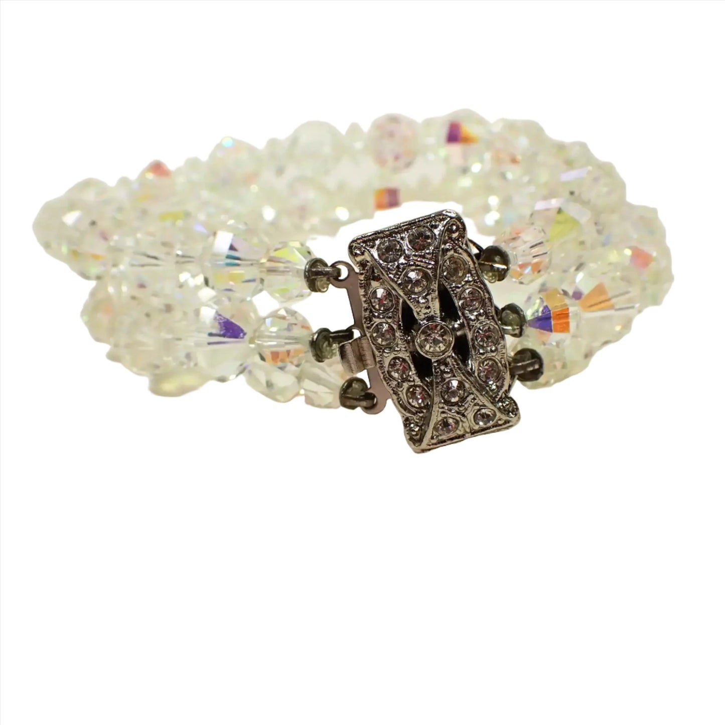 Front view of the Mid Century vintage multi strand AB crystal beaded bracelet. There are faceted round and saucer shaped glass crystal beads with a flashy multi color aurora borealis coating. There is a large rectangle box clasp at the end that has clear round rhinestones on the top. 
