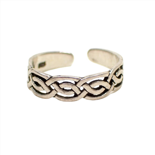 Front view of the retro vintage sterling silver toe ring. It has a slightly darkened patina and a Celtic style filigree braided design. The back is open with rounded corners so it can be adjusted for size.