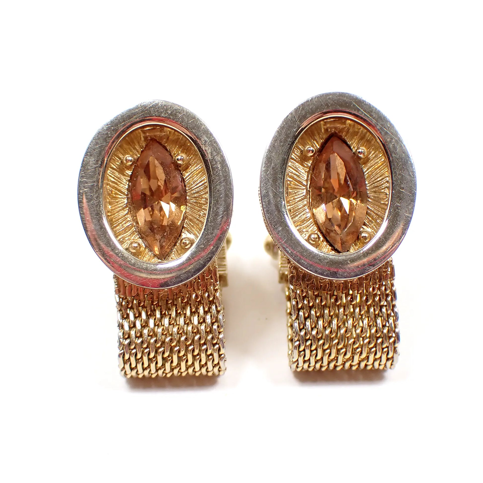 Front view of the Swank Mid Century vintage wrap around mesh cufflinks. The metal is gold tone in color. There are ovals in the front with textured ovals behind it. In the middle are marquis cut light brown rhinestones.
