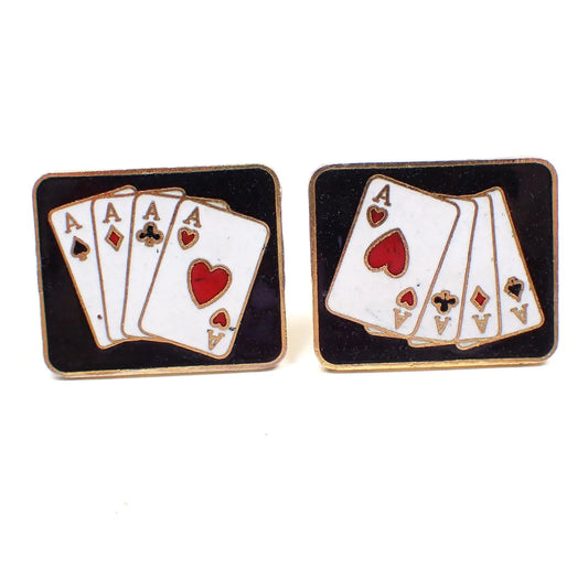Front view of the retro vintage playing card cufflinks. They are rectangular in shape with gold tone color metal. The fronts have black enamel with white, black, and red playing card design showing a 4 of a kind Poker hand with Aces. 