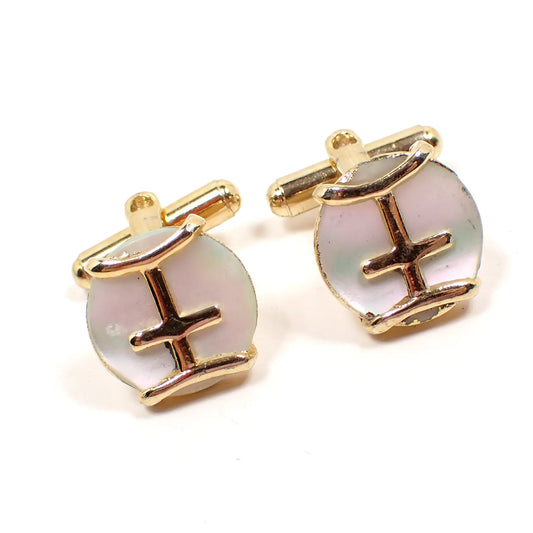 Front view of the retro vintage mother of pearl cufflinks. The metal is gold in color and has a curved bar design on the front over pearly white mother of pearl shell cabs.