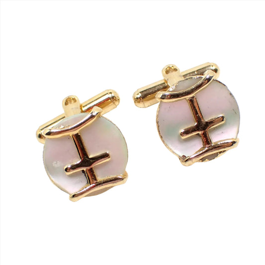 Front view of the retro vintage mother of pearl cufflinks. The metal is gold in color and has a curved bar design on the front over pearly white mother of pearl shell cabs.
