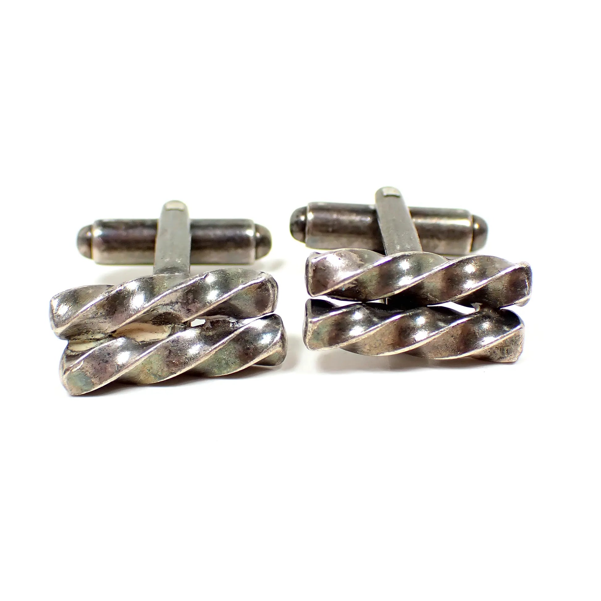 Front view of the retro vintage sterling silver cufflinks. The sterling has darkened to a gray and silver color from age. The fronts have two short twisted bars next to each other.
