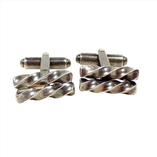 Front view of the retro vintage sterling silver cufflinks. The sterling has darkened to a gray and silver color from age. The fronts have two short twisted bars next to each other.