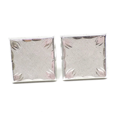 Front view of the Mid Century vintage Hayward cufflinks. They are square in shape and silver tone in color. The fronts have a brushed matte appearance with a cut etched edge and corner design.