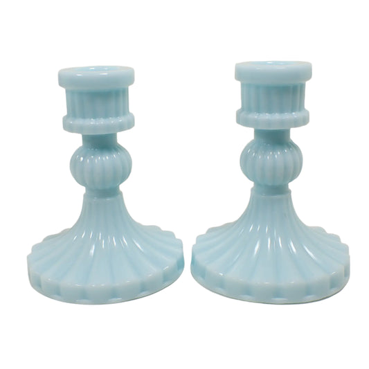 Side view of the handmade candlestick holders. The resin is a cotton candy pastel blue color. They have a flared round bottom, a round sphere shaped middle, and a round barrel shaped top for a vintage style appearance. 