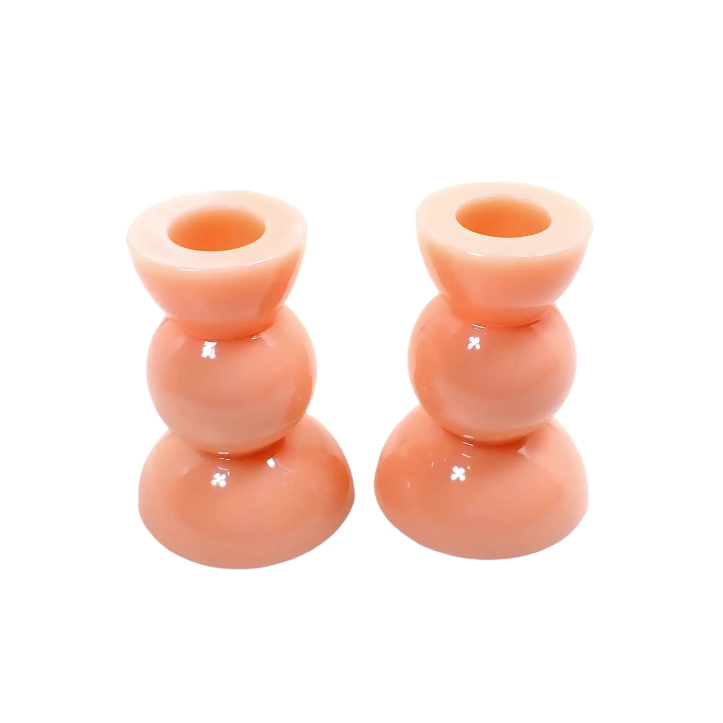 Angled view of the handmade candle holders. They are a light pastel peach in color.