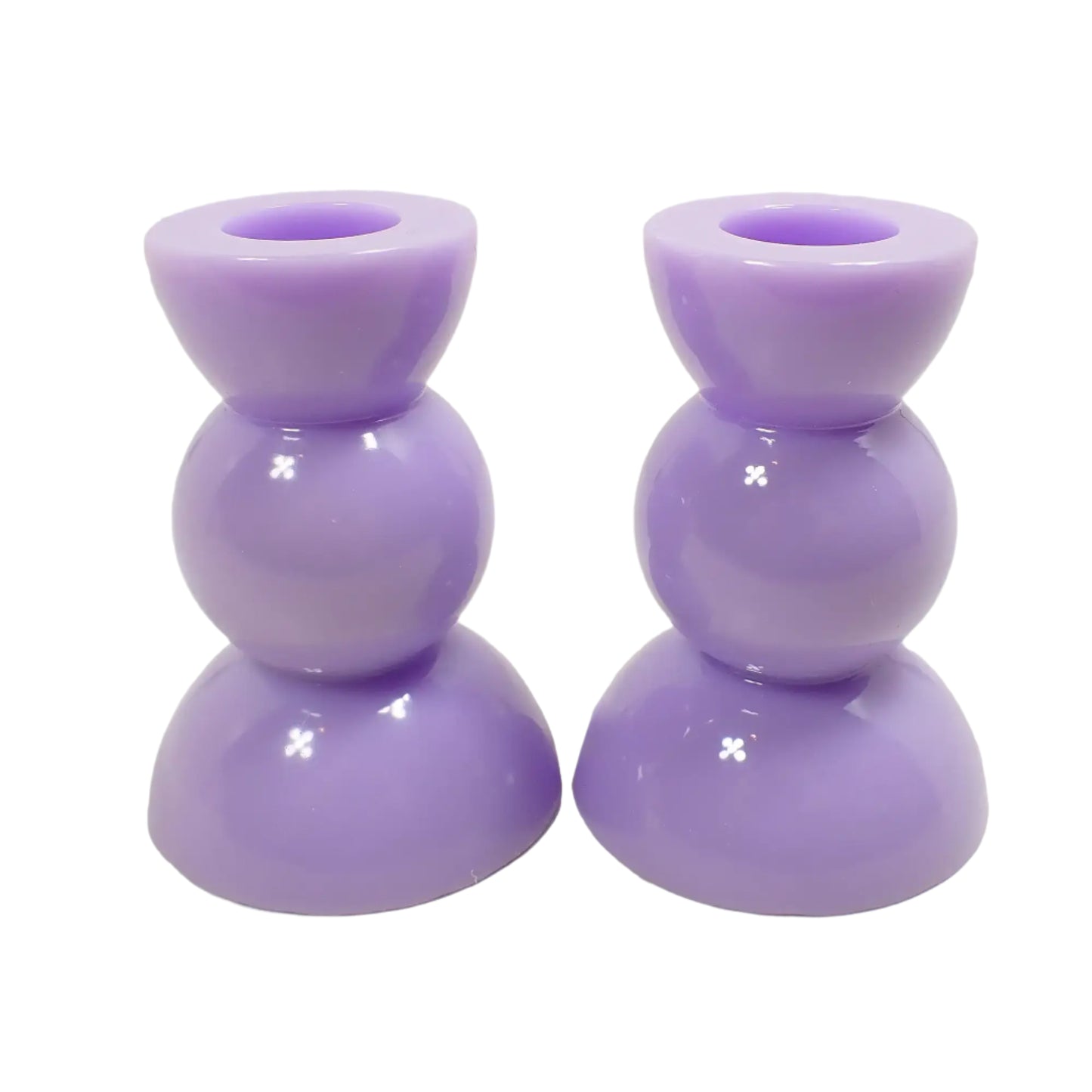 Side view of the handmade resin candle holders. They are a shiny light pastel purple in color. They have a round geometric shape with half sphere at top and bottom and sphere shape in the middle.