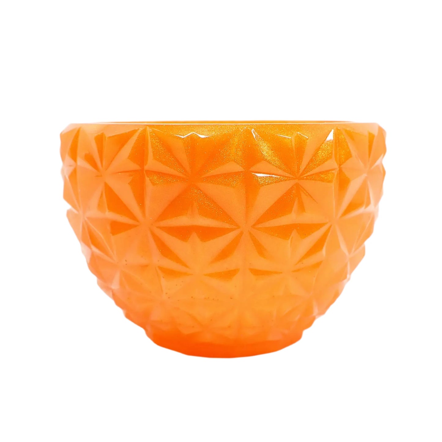 Side view of the handmade pearly orange bowl showing the faceted design. It looks like square areas with faceted star like shapes.