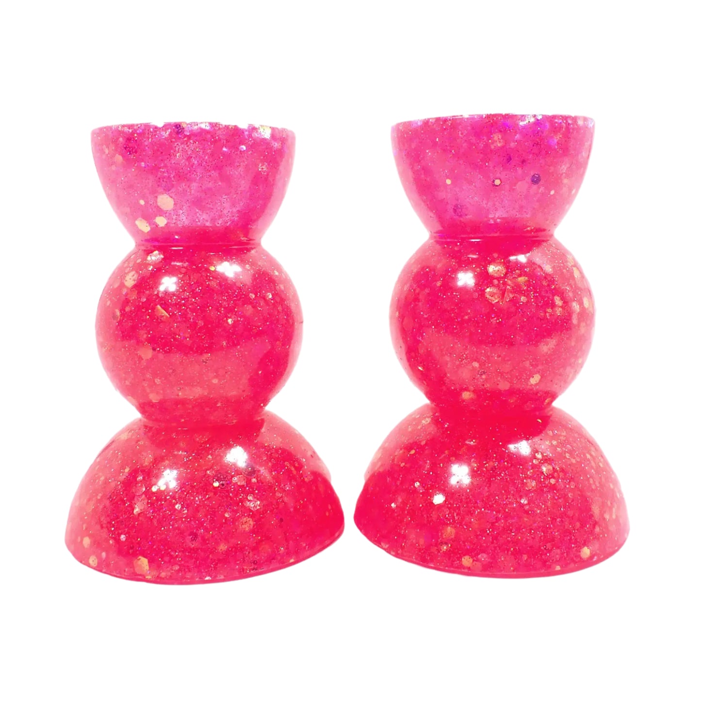 Side view of the handmade resin candle holders. Flashes of sparkle can be seen from the glitter. There is a half sphere shape at the top and bottom of the candlestick holders and a round sphere shape in the middle for a geometric appearance.