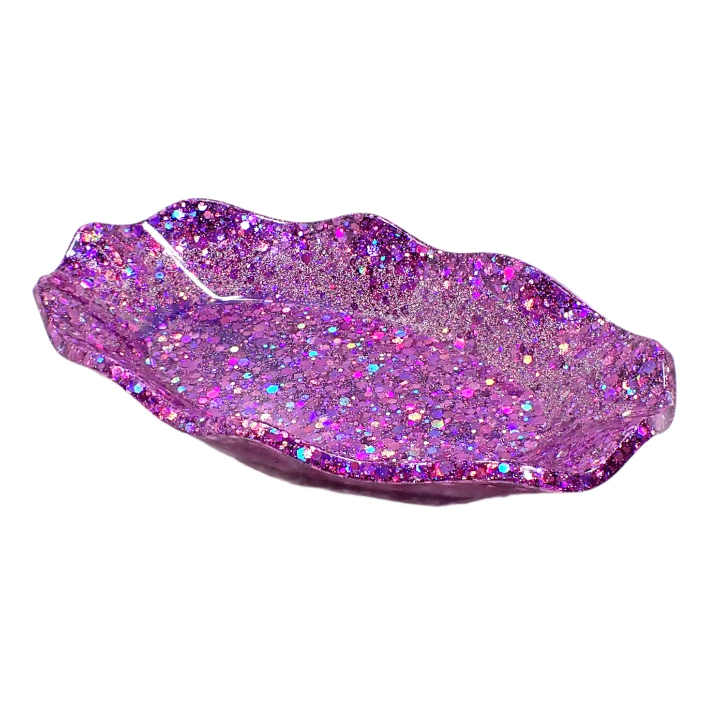 Angled side view of the handmade purple glitter resin wavy trinket dish. It is shaped like an oval with curvy wavy edges that are angled out around the piece.