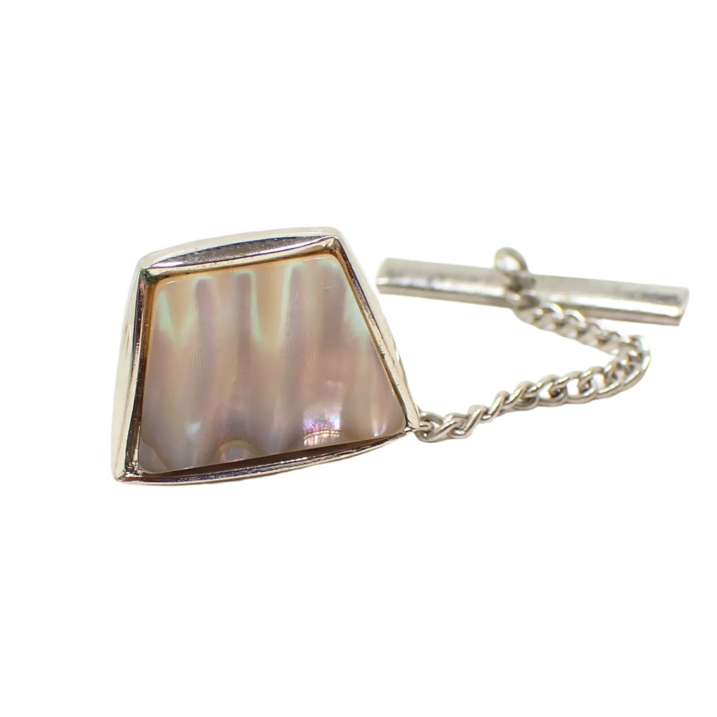 Angled view of the vintage mother of pearl shell tie tack. The trapezoid shape has rounded edges. 