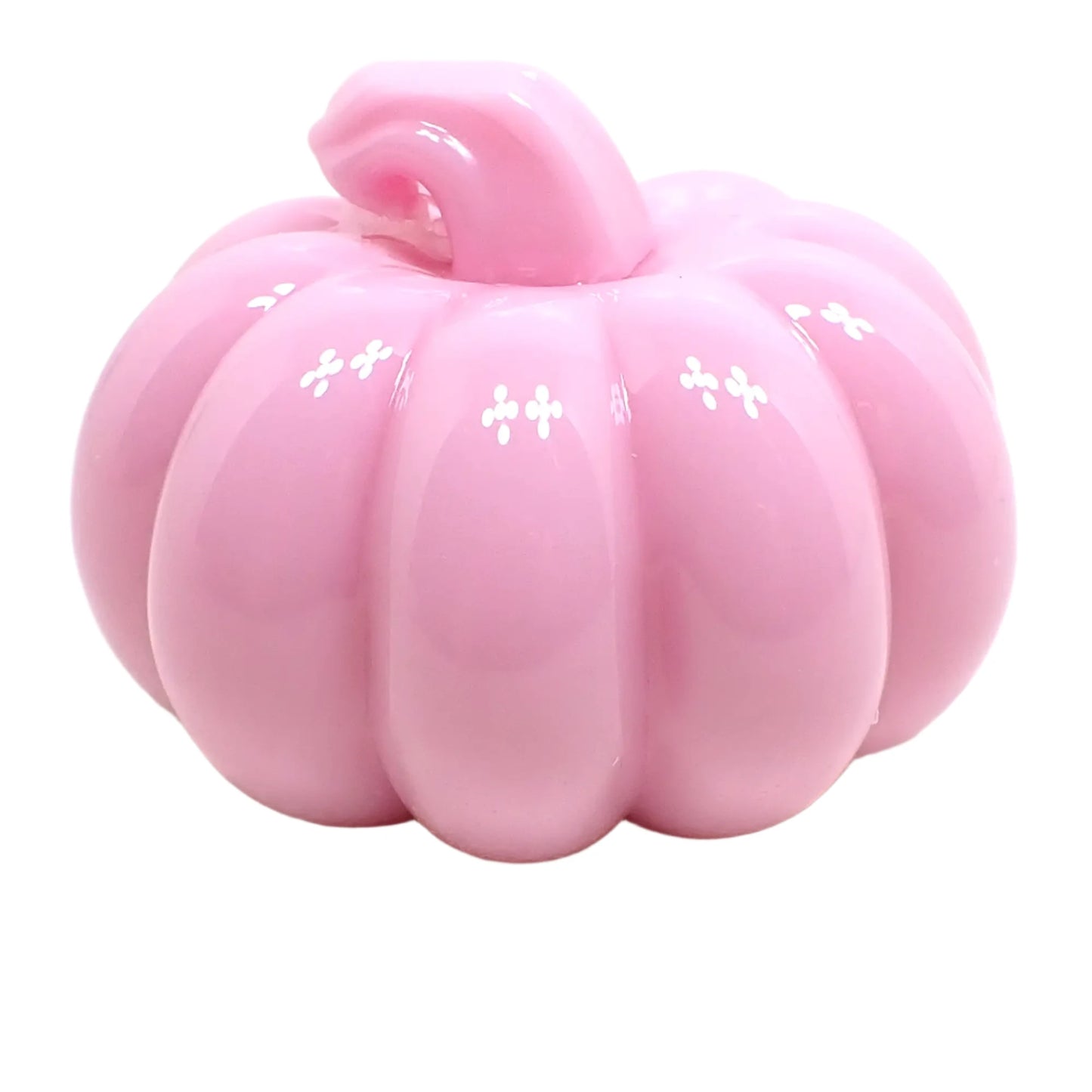 Angled view of the shiny resin pumpkin. It is pastel pink in color with a curved stem that has a flat top.