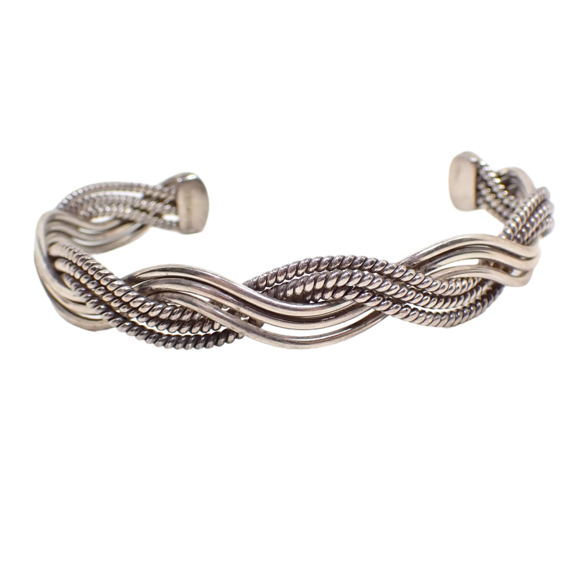 Front view of the vintage sterling silver cuff bracelet. It is antiqued silver in color. There are three smooth curvy wires and three textured curvy wires braided to make the cuff. 