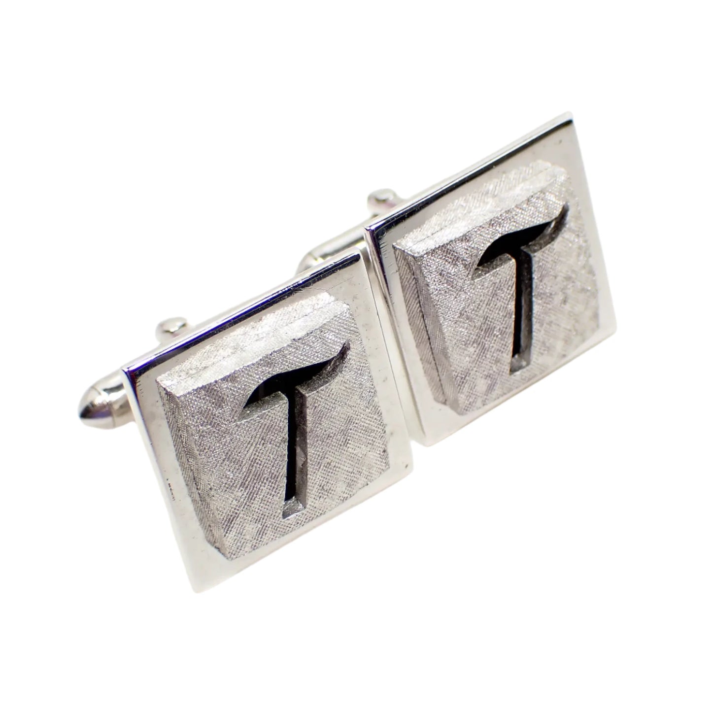 Another angled view of the Swank initial letter T cufflinks. They have a double square design with a matte silver tone middle and shiny silver tone edge.