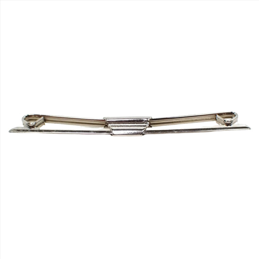 Front view of the Mid Century vintage collar clip. The front has an angled design with tapered ends. The back has angled curls at the ends. Collar stay is silver tone plated in color.