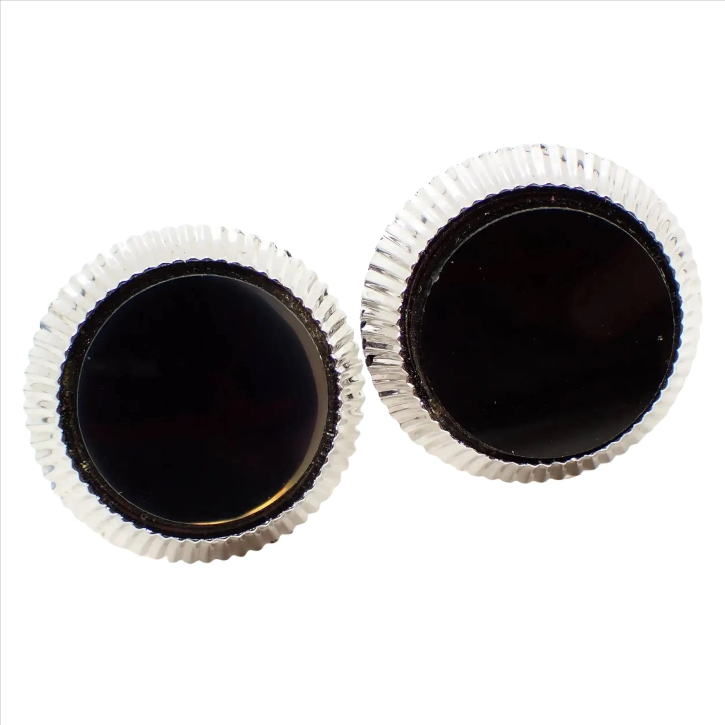 Enlarged front view of the retro vintage Hickok Cufflinks. They are silver tone plated in color and have a round shape. There is a corrugated textured edge and a flat round black glass cab in the middle.