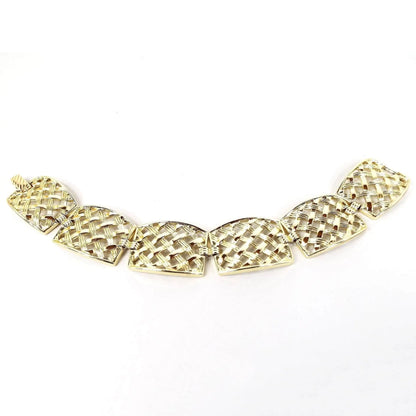 Top view of the Mid Century vintage Sarah Coventry panel bracelet. It is gold tone in color and has large rectangle shaped links with a basket weave style design on them. There is a snap lock clasp on the end.