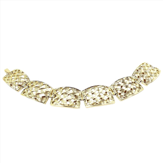 Top view of the Mid Century vintage Sarah Coventry panel bracelet. It is gold tone in color and has large rectangle shaped links with a basket weave style design on them. There is a snap lock clasp on the end.