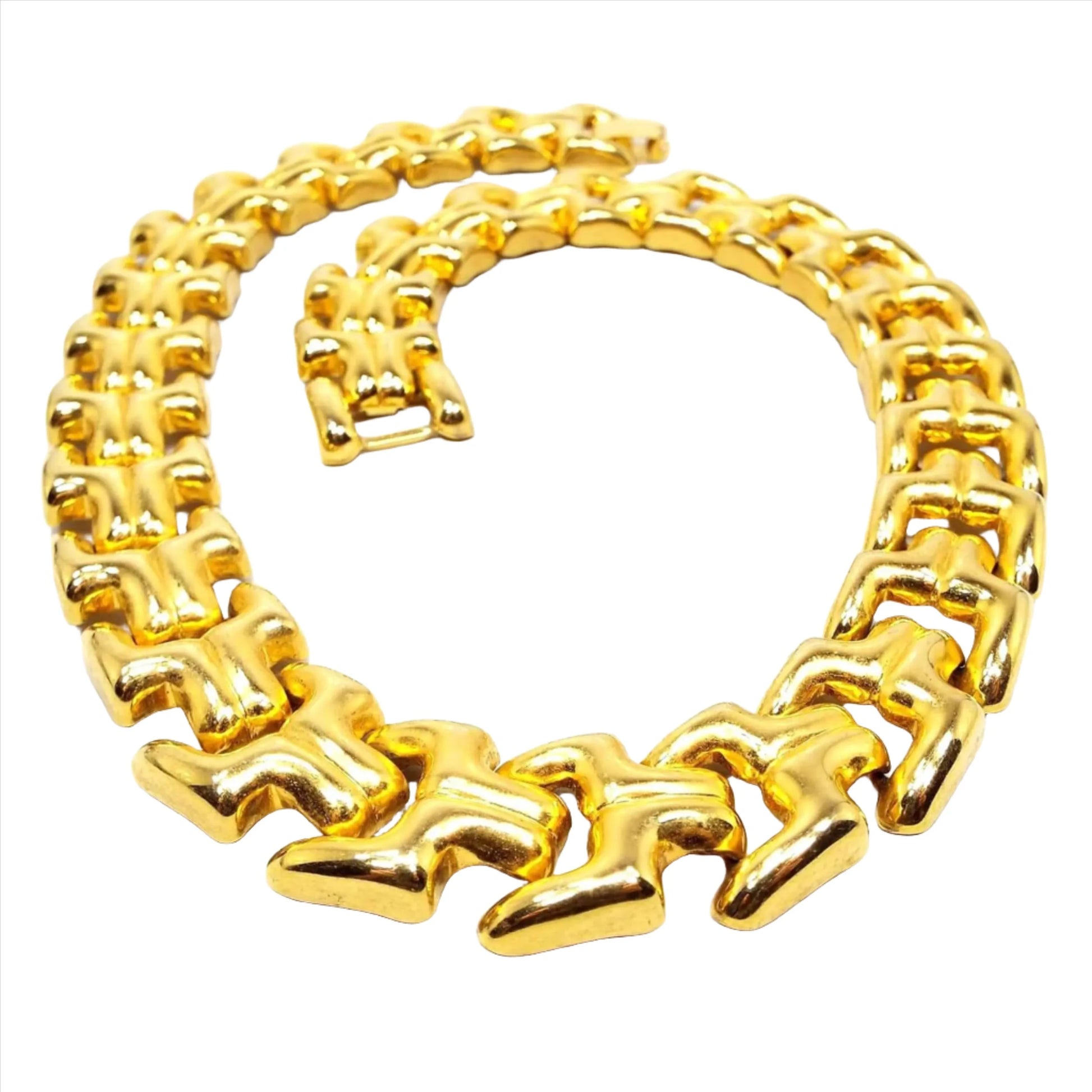 Front view of the retro vintage large link necklace. The metal is a yellow gold tone in color. There are large boxy sideways Y shaped links and a snap lock clasp on the end.