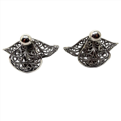 Front view of the Mid Century vintage filigree clip on earrings. They are a darker silver tone in color with a curved filigree fan like shape.