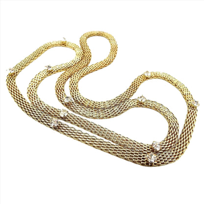 Front view of the retro vintage rhinestone mesh necklace. The chain has a mesh design throughout the entire length. There are eleven round clear rhinestones spaced apart so they are on the sides and bottom part of the necklace while the top is just mesh. There is no clasp as the necklace is long enough to slide over your head.