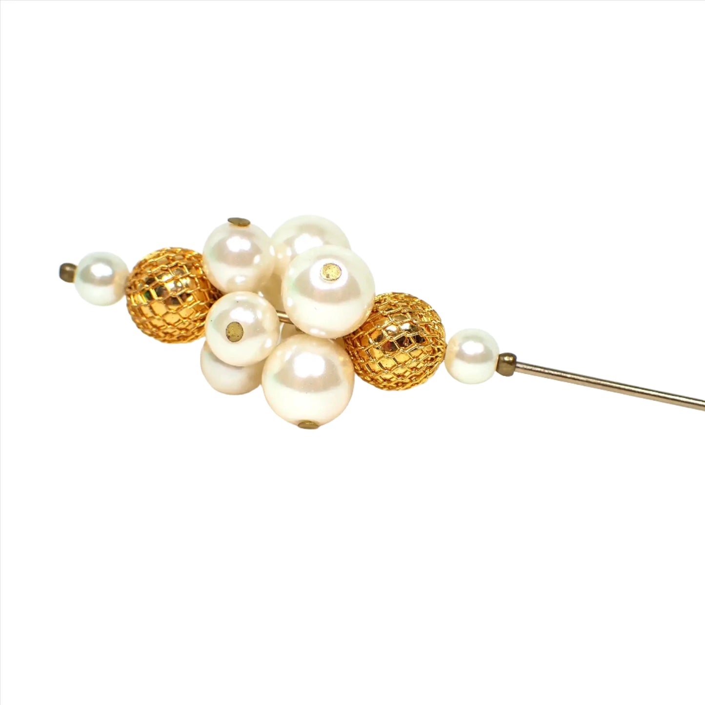 Enlarged view of the top of the retro vintage hat pin. There are faux pearl plastic beads in pearly  round beads at the top and bottom of the beaded area and a cluster of white faux pearl beads in the middle. The faux pearl beads are separated by textured gold tone round beads. You can see my reflection taking the photo in areas of the gold tone plated beads.