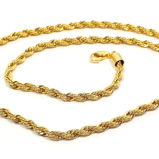 Close up view of the Pre Owned Modern rope chain necklace. It is bright gold tone plated in color and has a lobster claw clasp at the end. The chain has a twisted rope link design.