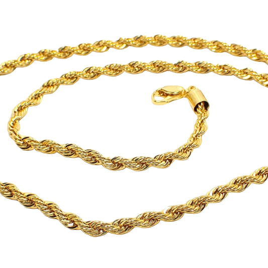 Close up view of the Pre Owned Modern rope chain necklace. It is bright gold tone plated in color and has a lobster claw clasp at the end. The chain has a twisted rope link design.