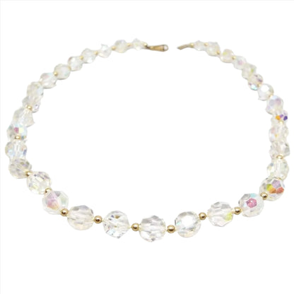 Top view of the Mid Century vintage AB crystal beaded necklace. It has faceted AB crystal glass rounded beads with small gold tone color round beads in between them. There is one strand with a hinged clip style clasp at the end.