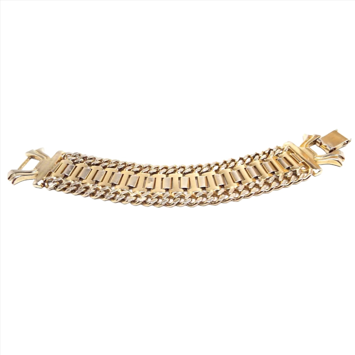 Angled view of the Mid Century vintage wide link chain bracelet. It is gold tone in color and has curved rectangle links the in the middle and faceted curb link chain on either side. There is a large snap lock clasp on the end.