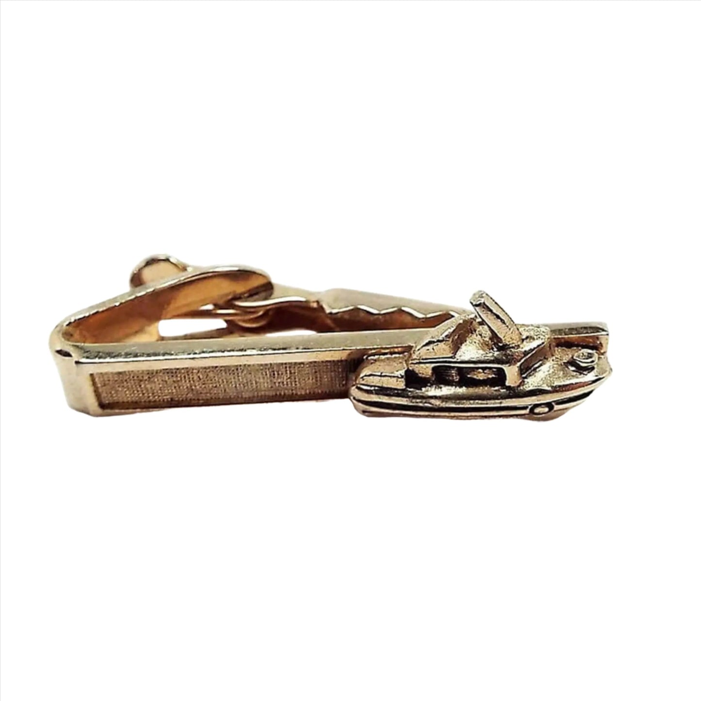 Front view of the Mid Century vintage boat tie clip by Shields. It is gold tone in color. The front is textured and has a 3D style yacht on the end.