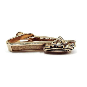 Front view of the Mid Century vintage boat tie clip by Shields. It is gold tone in color. The front is textured and has a 3D style yacht on the end.