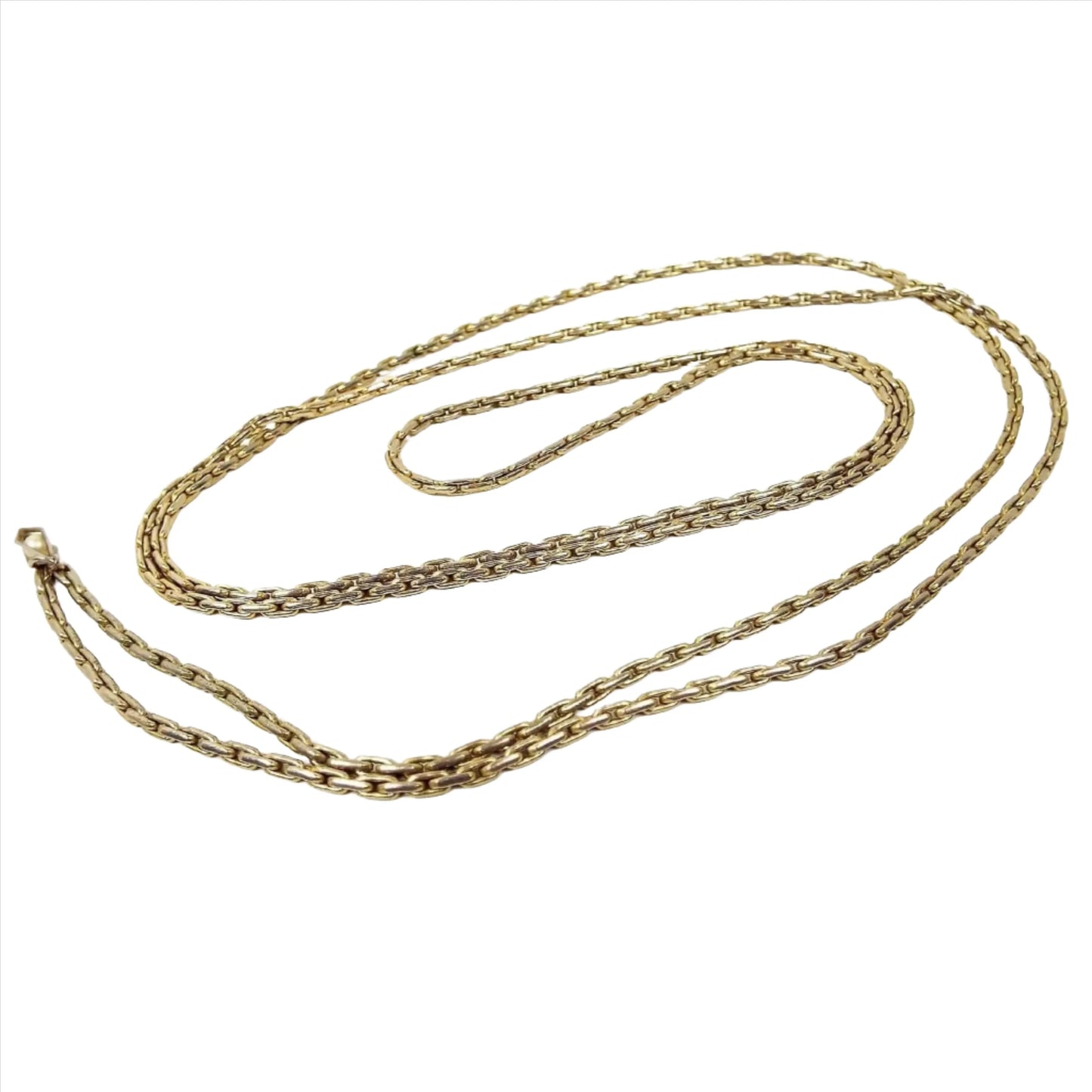 Top view of the retro vintage square link chain necklace. The metal is gold tone in color and a fancy rounded edge square link design. At the end there is a small faceted bottom teardrop charm with a faux pearl in it. There is no clasp as it's long and goes over your head.
