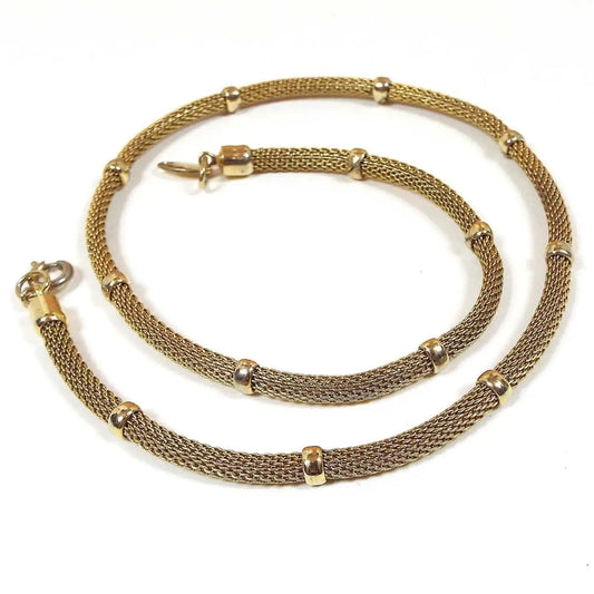 Chain is gold in color with round mesh between permanently affixed round gold color beads. It has a spring ring round type clasp. 