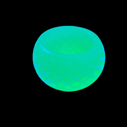 Photo of the handmade two tone green resin decorative bowl with diamond pattern showing how it fluoresces under a UV light.