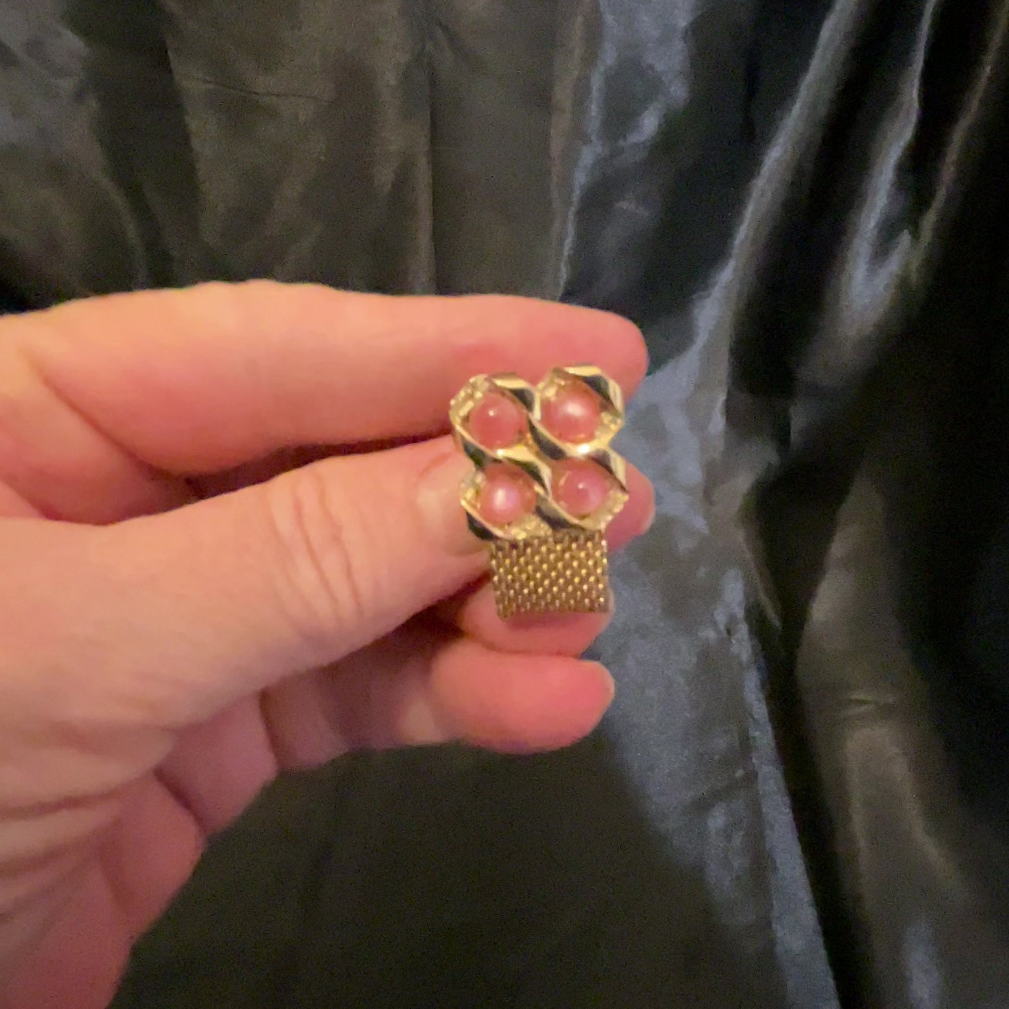 Video of the Mid Century vintage moonglow lucite wrap around cufflinks showing how the light pink cabs have a glow like effect as the light hits them.