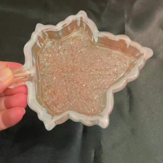 Video of the handmade opalescent and colorshift resin leaf decorative trinket dish showing how the bottom faceted crystal like area sparkles in the light.