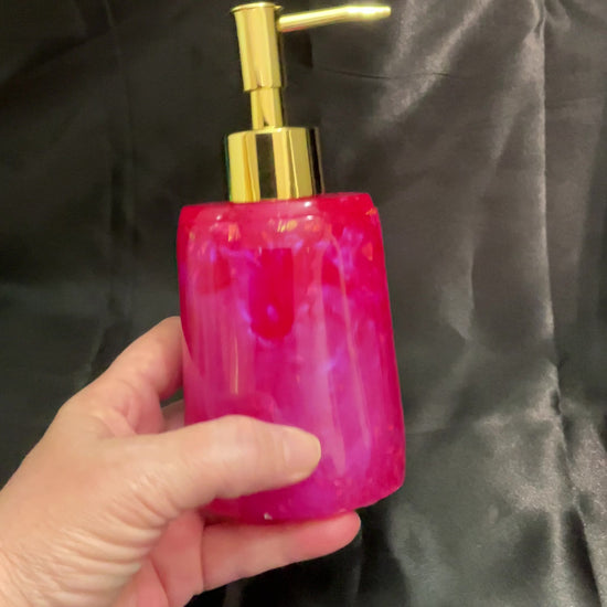 Video of the oval bright pink handmade resin soap dispenser showing how the iridescent flakes flash in the light.