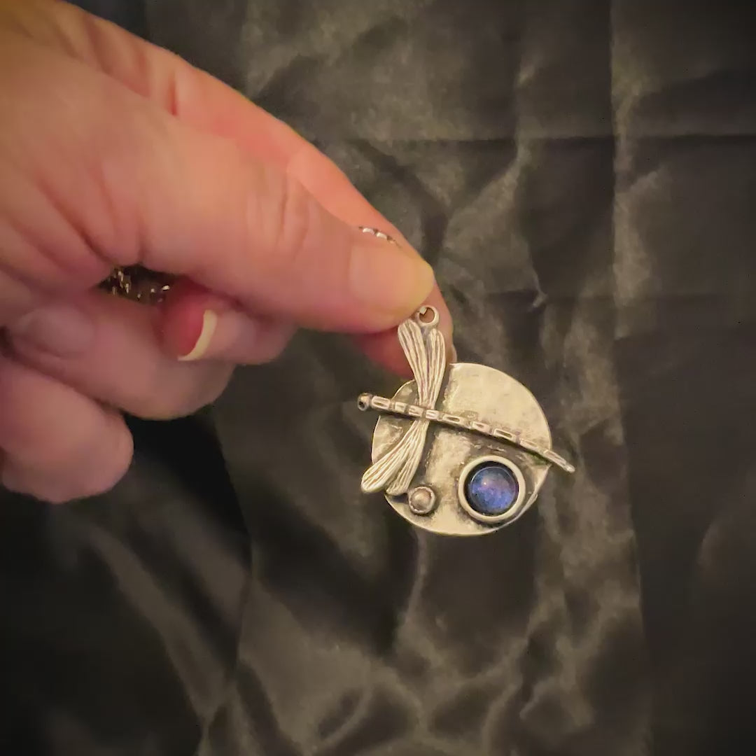 Video of the color shift dragonfly pendant showing how the resin cab goes from blue to purple depending on how the light is hitting it.